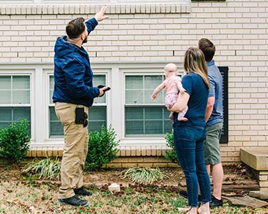 A family consulting with their home inspector during a pre-purchase home inspection.